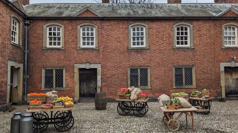 A view of the Servants Courtyard. the space is dressed with barrows and fruits inspired by delivery days.